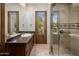 Bathroom featuring granite vanity, sink, and frameless glass shower with tile surround at 11717 E Estrella Ave, Scottsdale, AZ 85259