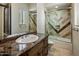 Bathroom showcases a vanity with granite countertop, a sink, and tiled shower at 11717 E Estrella Ave, Scottsdale, AZ 85259