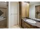 Bathroom features a sink, custom cabinetry, and a frameless glass shower with tile surround at 11717 E Estrella Ave, Scottsdale, AZ 85259