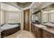 Luxurious bathroom with marble countertops, custom cabinets, and a soaking tub at 11717 E Estrella Ave, Scottsdale, AZ 85259