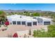 Aerial view of an estate showcasing a multiple car garage with lush landscaping and mountain views at 11717 E Estrella Ave, Scottsdale, AZ 85259