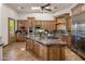 Spacious kitchen boasts wooden cabinetry, stainless steel appliances, and a large center island with a gas cooktop at 11717 E Estrella Ave, Scottsdale, AZ 85259