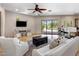 Bright living room featuring a ceiling fan, tile flooring, and sliding glass doors to the outdoor pool area at 11717 E Estrella Ave, Scottsdale, AZ 85259