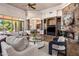 Spacious living room with a stone fireplace, custom built-ins, and access to the outdoor patio at 11717 E Estrella Ave, Scottsdale, AZ 85259