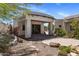 Back patio featuring stone pavers, a covered porch, and lush desert landscaping at 11717 E Estrella Ave, Scottsdale, AZ 85259