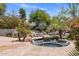 Backyard pool and hot tub surrounded by mature landscaping with palm trees, rocks, and a tranquil atmosphere at 11717 E Estrella Ave, Scottsdale, AZ 85259