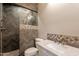 Well-lit bathroom featuring a herringbone tiled shower, decorative tile accents, and a white vanity with bronze fixtures at 18283 N 93Rd St, Scottsdale, AZ 85255