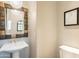 Elegant powder room with a decorative mirror, pedestal sink, and designer lighting at 18283 N 93Rd St, Scottsdale, AZ 85255