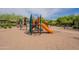 A colorful playground with a slide and climbing equipment amidst a sandy play area at 18283 N 93Rd St, Scottsdale, AZ 85255