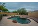 Scenic backyard with a uniquely shaped private pool, featuring rock accents and a wood deck, surrounded by mature trees at 18283 N 93Rd St, Scottsdale, AZ 85255