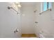 All-white tiled shower in the bathroom with patterned tile floors and bright lighting at 2118 E Oak St, Phoenix, AZ 85006
