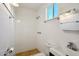 All-white tiled shower in the bathroom with patterned tile floors and bright lighting at 2118 E Oak St, Phoenix, AZ 85006