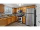 Well-appointed kitchen featuring stainless steel appliances, tile backsplash, wood cabinets and easy access to living area at 2118 E Oak St, Phoenix, AZ 85006