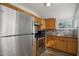 Updated kitchen featuring stainless steel appliances, granite counters, tile backsplash and wooden cabinets and hardware at 2118 E Oak St, Phoenix, AZ 85006
