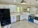 Modern kitchen featuring white shaker cabinets, stainless appliances, floating shelves, and a window view at 2138 E Williams Dr, Phoenix, AZ 85024