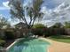 Relaxing backyard pool with waterfall feature, desert landscaping, and beautiful Arizona skies at 2138 E Williams Dr, Phoenix, AZ 85024