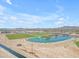 Aerial view of community park featuring lake, playground, sports fields, and desert landscaping under a blue sky at 23693 W Grove St, Buckeye, AZ 85326