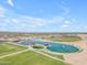 Community park aerial showcasing lake, ramadas, ball fields, volleyball courts, playground, and green spaces at 23693 W Grove St, Buckeye, AZ 85326