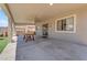 Covered patio area showcases outdoor living with a swing, table, and view of the backyard at 23693 W Grove St, Buckeye, AZ 85326