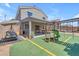 Backyard with covered patio, swing and play structure on artificial grass at 23693 W Grove St, Buckeye, AZ 85326