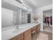 Bright bathroom showcasing an extensive vanity, a makeup chair, and walk-in closet at 23693 W Grove St, Buckeye, AZ 85326