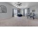 Spacious bedroom features a ceiling fan, carpeted floors, and plentiful natural light from multiple windows at 23693 W Grove St, Buckeye, AZ 85326