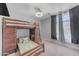This bedroom has a lofted bed with a built-in desk, a bed below, and windows providing lots of natural light at 23693 W Grove St, Buckeye, AZ 85326