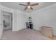 Bedroom featuring a ceiling fan, plush carpeting, a closet, and small desk area at 23693 W Grove St, Buckeye, AZ 85326