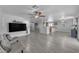 Spacious living room with grey wood flooring and a large tv at 23693 W Grove St, Buckeye, AZ 85326