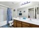 Bright bathroom with a double sink vanity, large mirror, and shower with nautical themed curtain at 23862 W Chambers St, Buckeye, AZ 85326