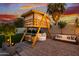 Backyard at night featuring a custom playhouse with lighting and outdoor seating under a dramatic sky at 2533 W Novak Way, Phoenix, AZ 85041