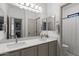 Bright bathroom featuring a double sink vanity, large mirror, and private toilet area at 2533 W Novak Way, Phoenix, AZ 85041