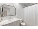 Bathroom with white vanity, decorative mirror, and a shower-tub combo at 2533 W Novak Way, Phoenix, AZ 85041