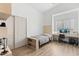 Modern bedroom featuring a twin bed, built in desk, wood floors, and window with blinds at 2533 W Novak Way, Phoenix, AZ 85041