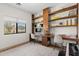 Bright home office featuring a long built-in desk, ample shelving, and natural light from the window at 2533 W Novak Way, Phoenix, AZ 85041
