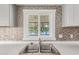 Close-up of the kitchen sink featuring stylish backsplash tiles and a bright, airy window view at 2650 W Union Hills Dr # 29, Phoenix, AZ 85027