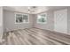 Bright living room with gray wood-look floors, natural light, and a modern ceiling fan at 2650 W Union Hills Dr # 29, Phoenix, AZ 85027