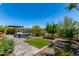 Inviting backyard featuring a pergola, stylish furniture, lush plants, and a small patch of artificial grass at 29403 N 119Th Ln, Peoria, AZ 85383