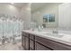 Bathroom featuring a double sink vanity with modern fixtures and coordinated floral-themed shower curtain at 29403 N 119Th Ln, Peoria, AZ 85383