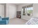 Bright bedroom with a comfortable blue armchair and a view of the outdoors through a large window at 29403 N 119Th Ln, Peoria, AZ 85383