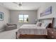 Bright bedroom features neutral tones, plush carpet, ceiling fan, and views of lush, green landscaping at 29403 N 119Th Ln, Peoria, AZ 85383