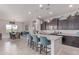 Bright kitchen featuring dark cabinets, stainless steel appliances, an island with seating, and a view of the dining area at 29403 N 119Th Ln, Peoria, AZ 85383