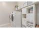 Well-organized laundry room with side-by-side washer and dryer, plus ample shelving at 29403 N 119Th Ln, Peoria, AZ 85383