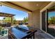 An outdoor kitchen with a stone counter, built-in grill, and seating offers an ideal spot for entertaining at 29403 N 119Th Ln, Peoria, AZ 85383