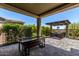 An expansive patio with pavers, a pergola with string lights, and lush landscaping provides a relaxing retreat at 29403 N 119Th Ln, Peoria, AZ 85383