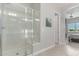 Clean shower with glass doors and tile, and a glimpse into the main bedroom from the bathroom at 29403 N 119Th Ln, Peoria, AZ 85383
