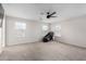 A spacious, carpeted bedroom with a ceiling fan, an electric massage chair, and plenty of natural light at 302 N 69Th Pl, Mesa, AZ 85207