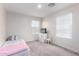 Cozy bedroom with a twin bed, dresser, and chair bathed in natural light from the two bright and sunny windows at 302 N 69Th Pl, Mesa, AZ 85207