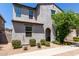 Charming two-story home featuring a textured facade, arched entryway, and well-maintained desert landscaping at 302 N 69Th Pl, Mesa, AZ 85207