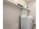 Well-organized laundry area featuring side-by-side washer and dryer under a floating shelf for storing laundry products at 302 N 69Th Pl, Mesa, AZ 85207
